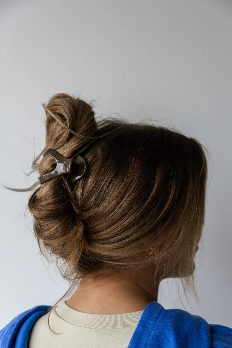 Model wearing kaxi lay down 2.0 claw clip in shiny dark brown.