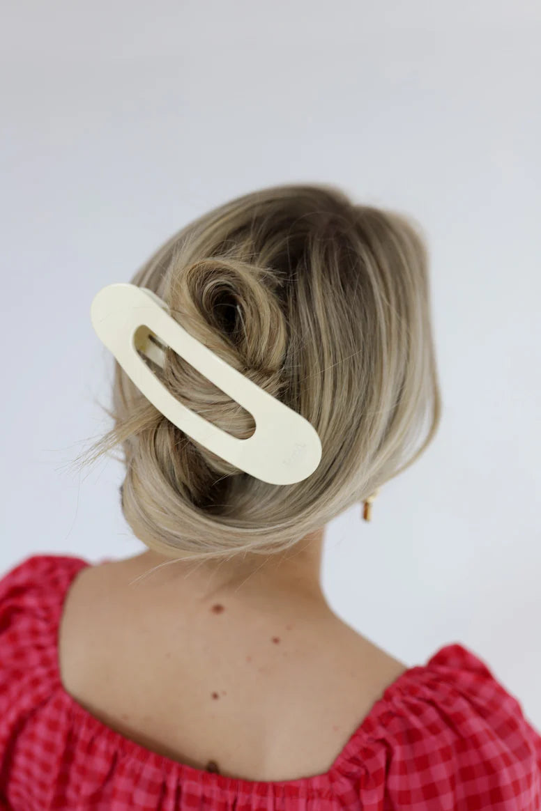 Model wearing a large, flat kaxi claw clip in a neutral matte color.