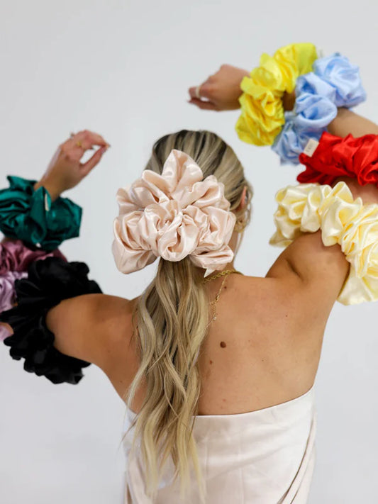 woman wearing kaxi jumbo sleep scrunchie in champagne color.