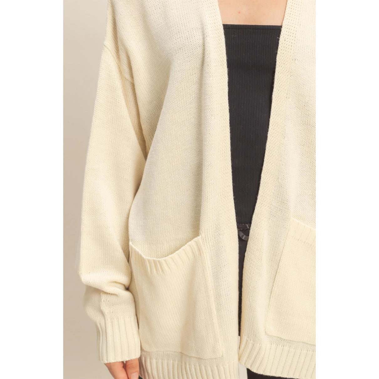 Woman wearing a cream oversized, open front cardigan