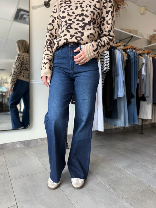 Woman wearing dark wash wide leg denim paired with leopard print sweater.