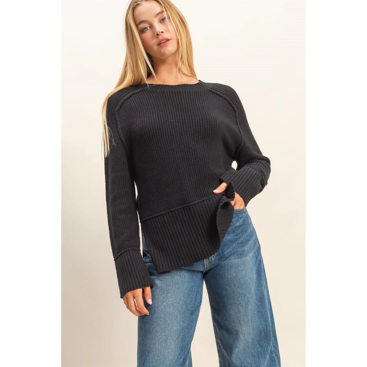 Woman wearing a black, rib knit, oversized sweater 