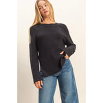 Woman wearing a black, rib knit, oversized sweater 