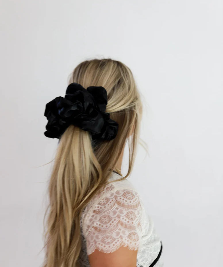 woman wearing kaxi jumbo sleep scrunchie in black.