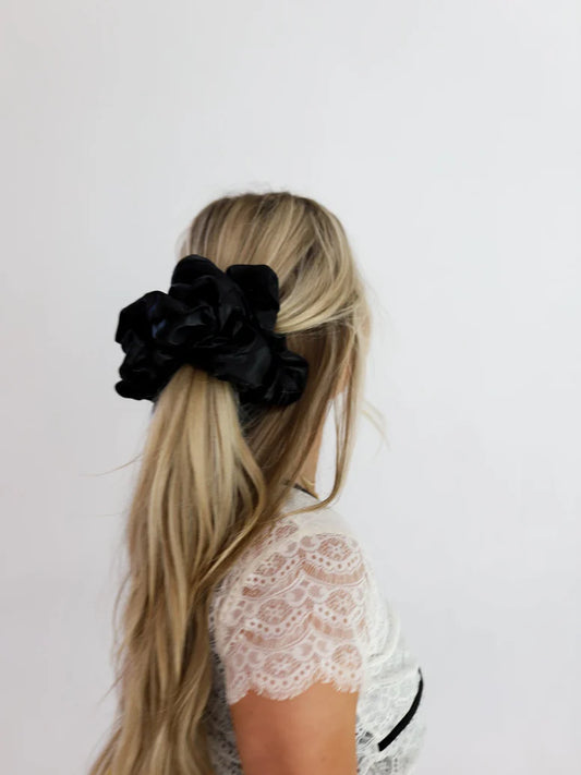 woman wearing kaxi jumbo sleep scrunchie in black.