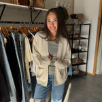 Woman wearing a cream oversized open cardigan with green basic tee shirt.