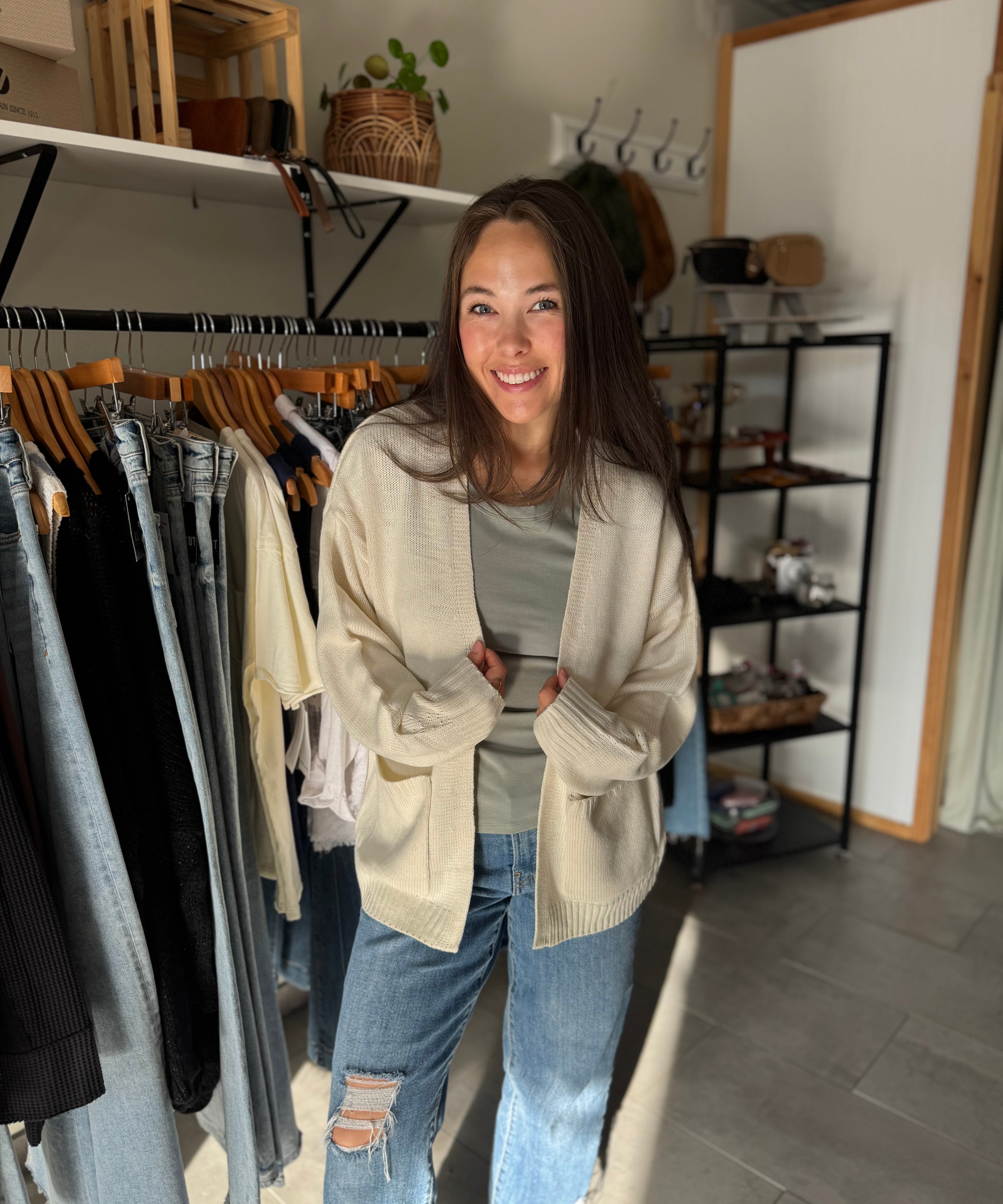 Woman wearing a cream oversized open cardigan with green basic tee shirt.