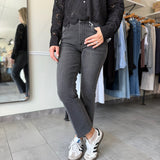 Woman wearing washed black denim with an embroidered detail top.