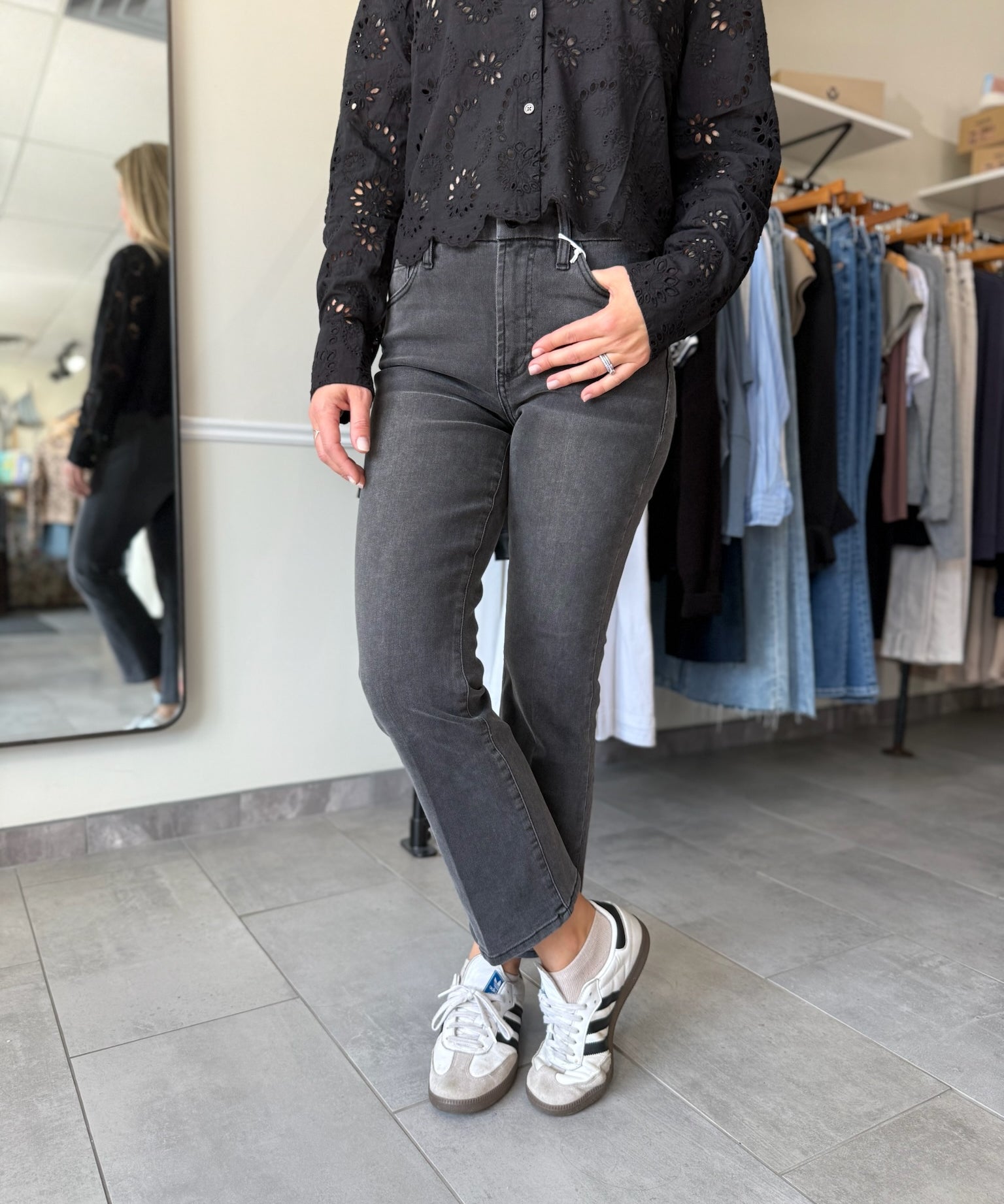 Woman wearing washed black denim with an embroidered detail top.