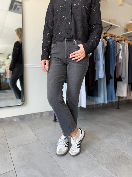 Woman wearing washed black denim with an embroidered detail top.
