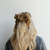 woman wearing kaxi jumbo scrunchie in cool brown.