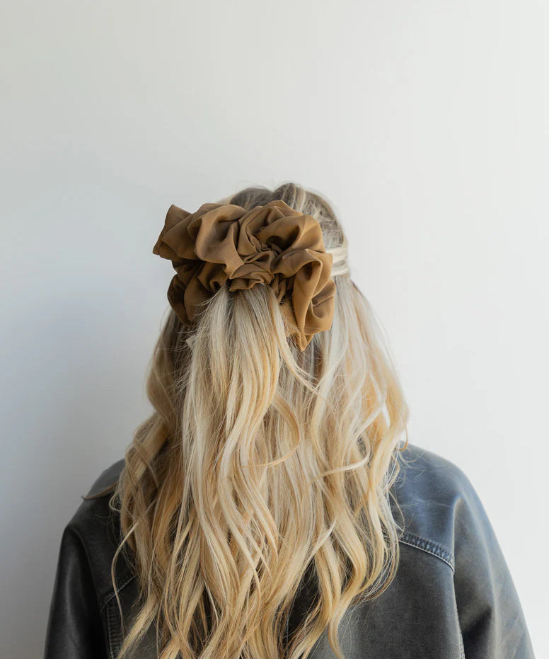 woman wearing kaxi jumbo scrunchie in cool brown.