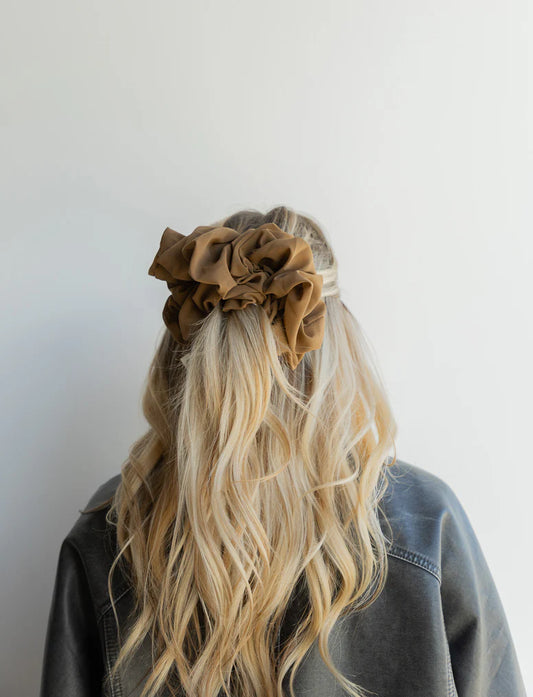woman wearing kaxi jumbo scrunchie in cool brown.