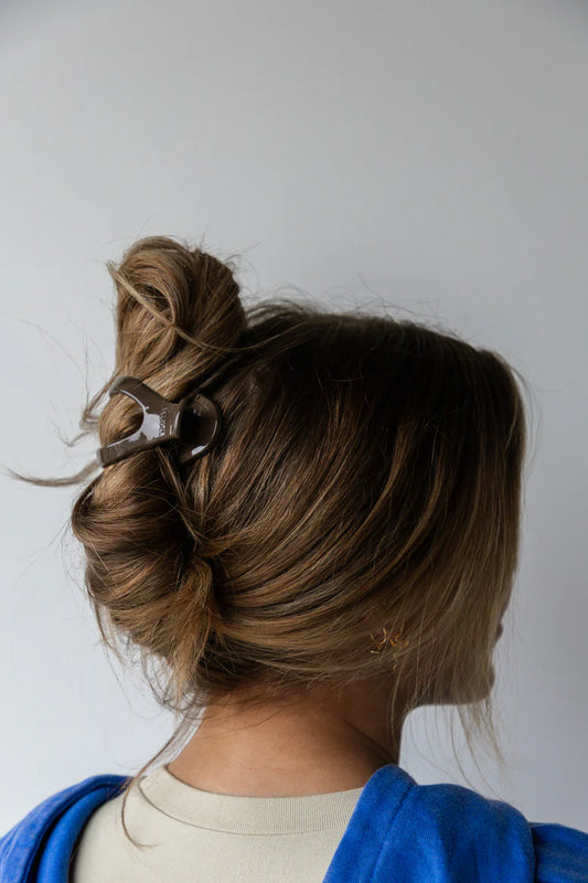 Model wearing kaxi lay down 2.0 claw clip in shiny dark brown.