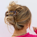 Model with long hair wearing a tortoiseshell print kaxi lay down claw clip
