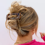 Model with long hair wearing a tortoiseshell print kaxi lay down claw clip