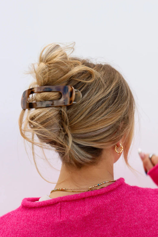 Model with long hair wearing a tortoiseshell print kaxi lay down claw clip