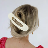 Model wearing a large, flat kaxi claw clip in a neutral matte color.
