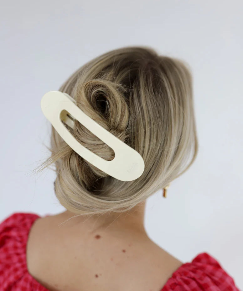 Model wearing a large, flat kaxi claw clip in a neutral matte color.