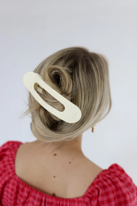 Model wearing a large, flat kaxi claw clip in a neutral matte color.