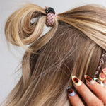 Hair tie with mauve and cream checkered print design and KAXI logo