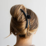 Model with long hair wearing Kaxi Matte Original Hold Everything Claw Clip in black.