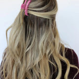 Model wearing kaxi mini hold everything claw clip in shiny rose pink.
