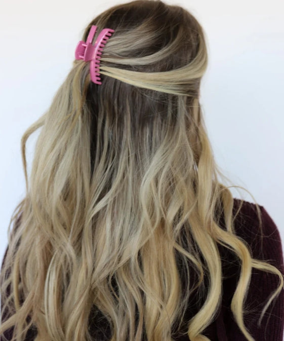 Model wearing kaxi mini hold everything claw clip in shiny rose pink.