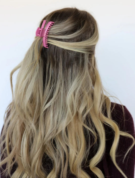 Model wearing kaxi mini hold everything claw clip in shiny rose pink.