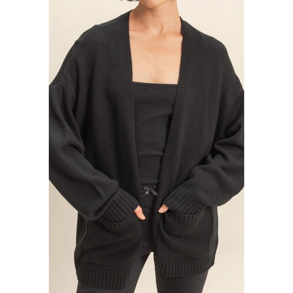 Woman wearing a black open front cardigan.
