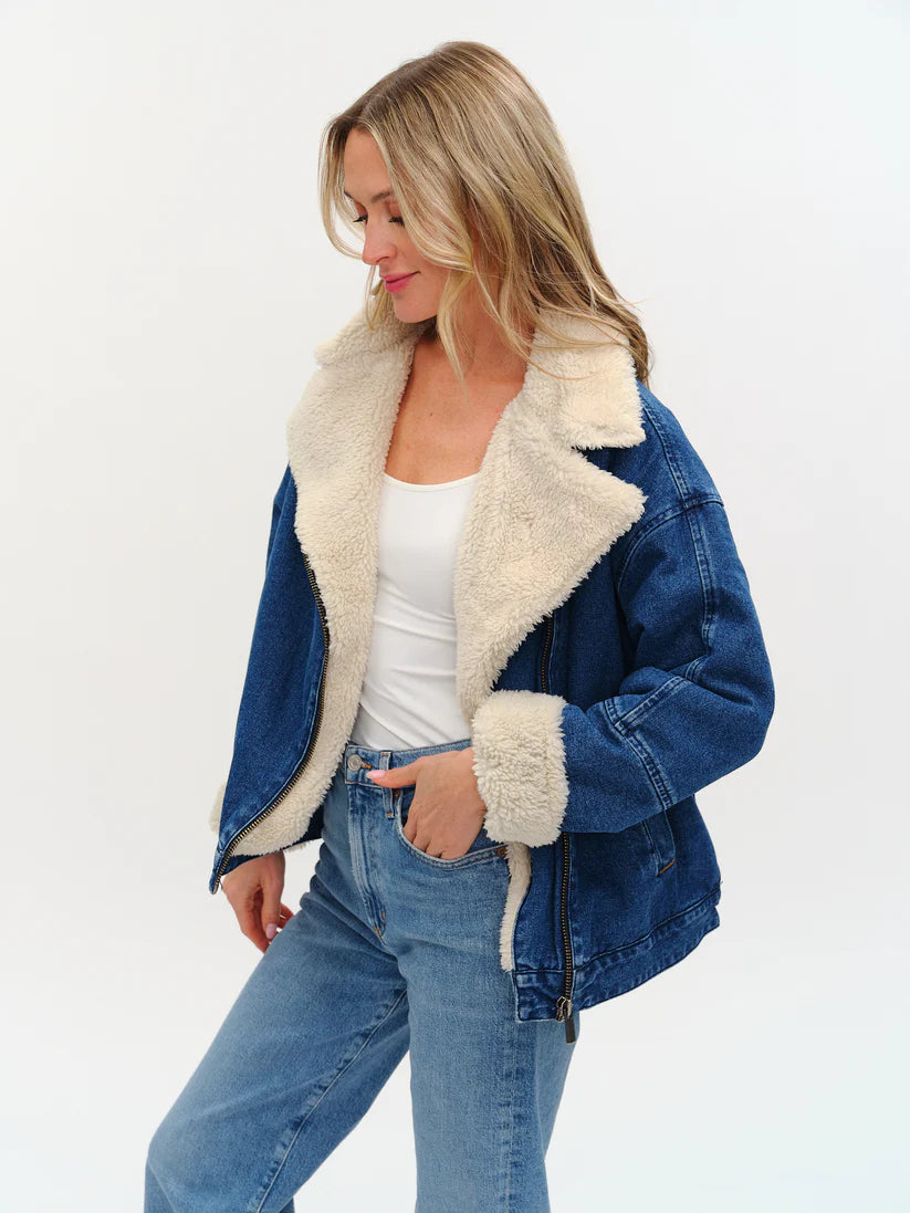 Model wearing an oversized denim jacket with sherpa lining from Six Fifty.