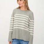 Woman wearing a gray sweater with white stripes.