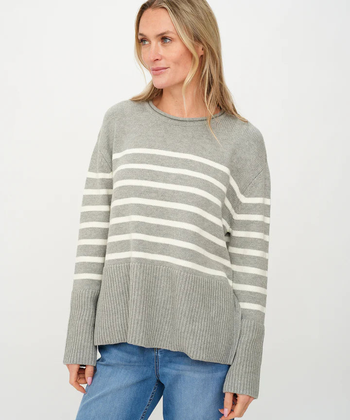 Woman wearing a gray sweater with white stripes.