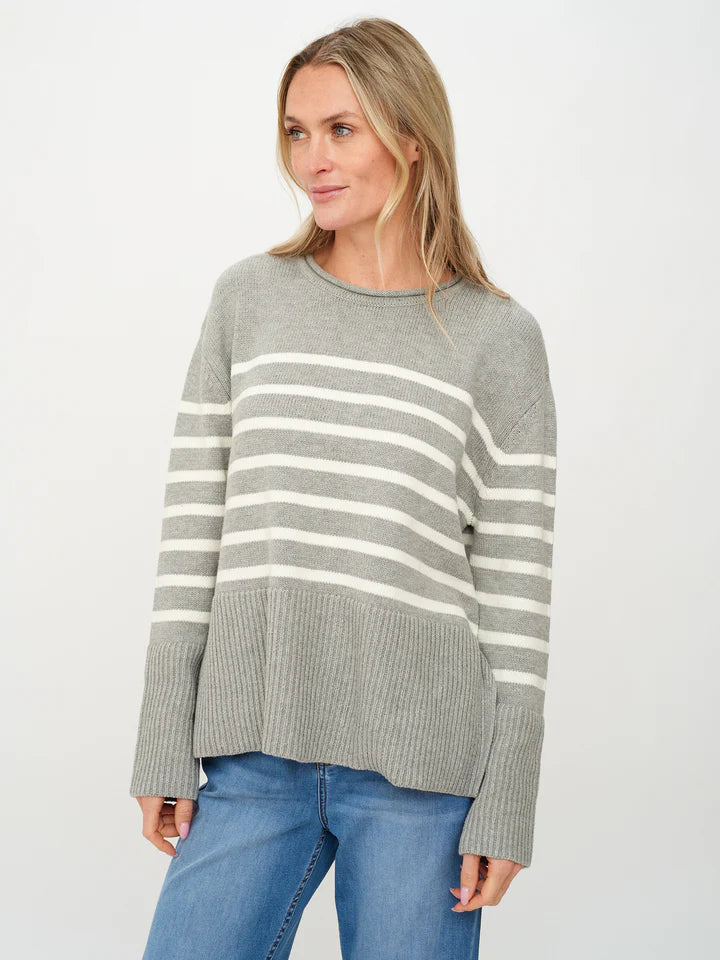 Woman wearing a gray sweater with white stripes.
